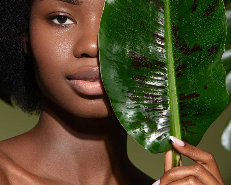Model holding plant leaf promoting organic skincare